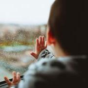 宝宝抚摸着被雨水淋湿的窗户